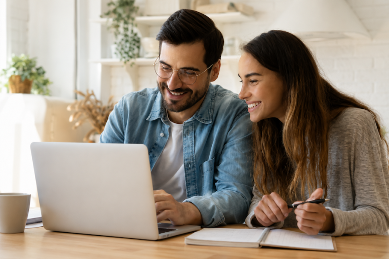 Young couple looking at computer on desk