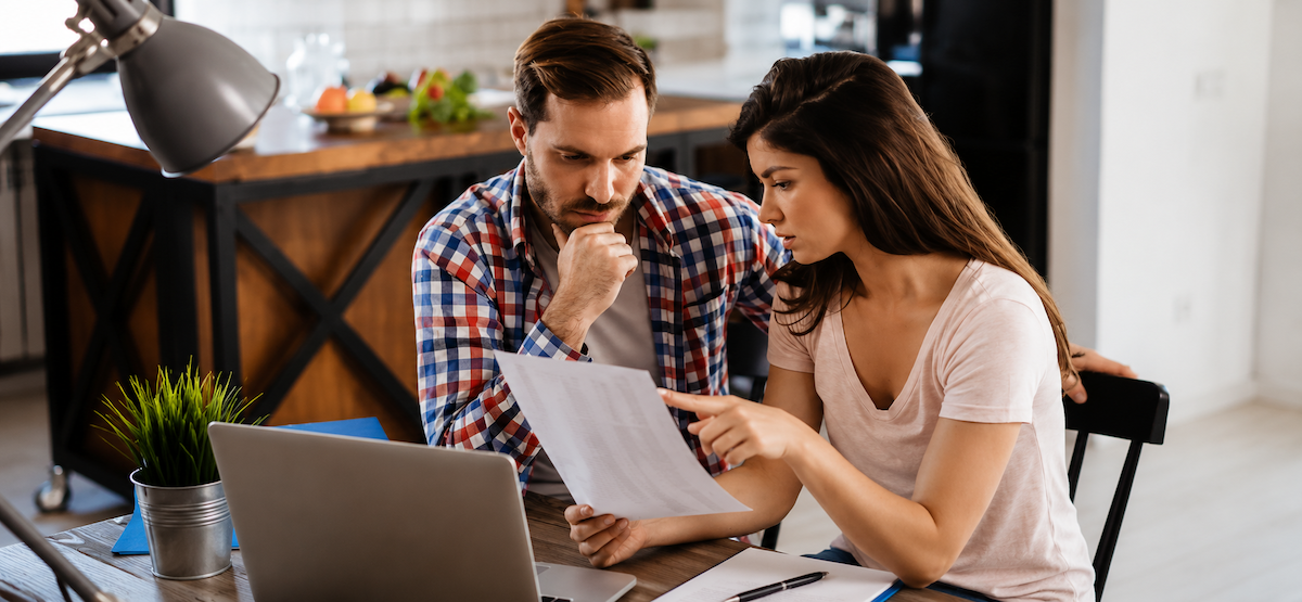 Young couple thinking while looking at paperwork