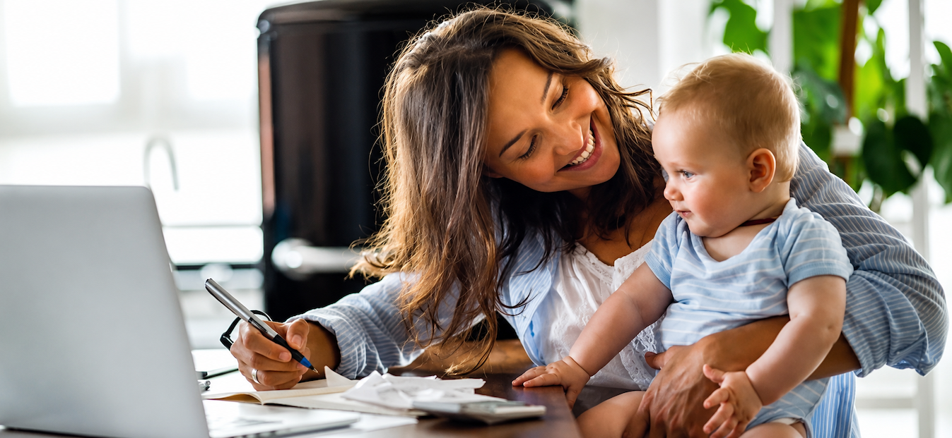 Baby with mom smiling while doing paperwork